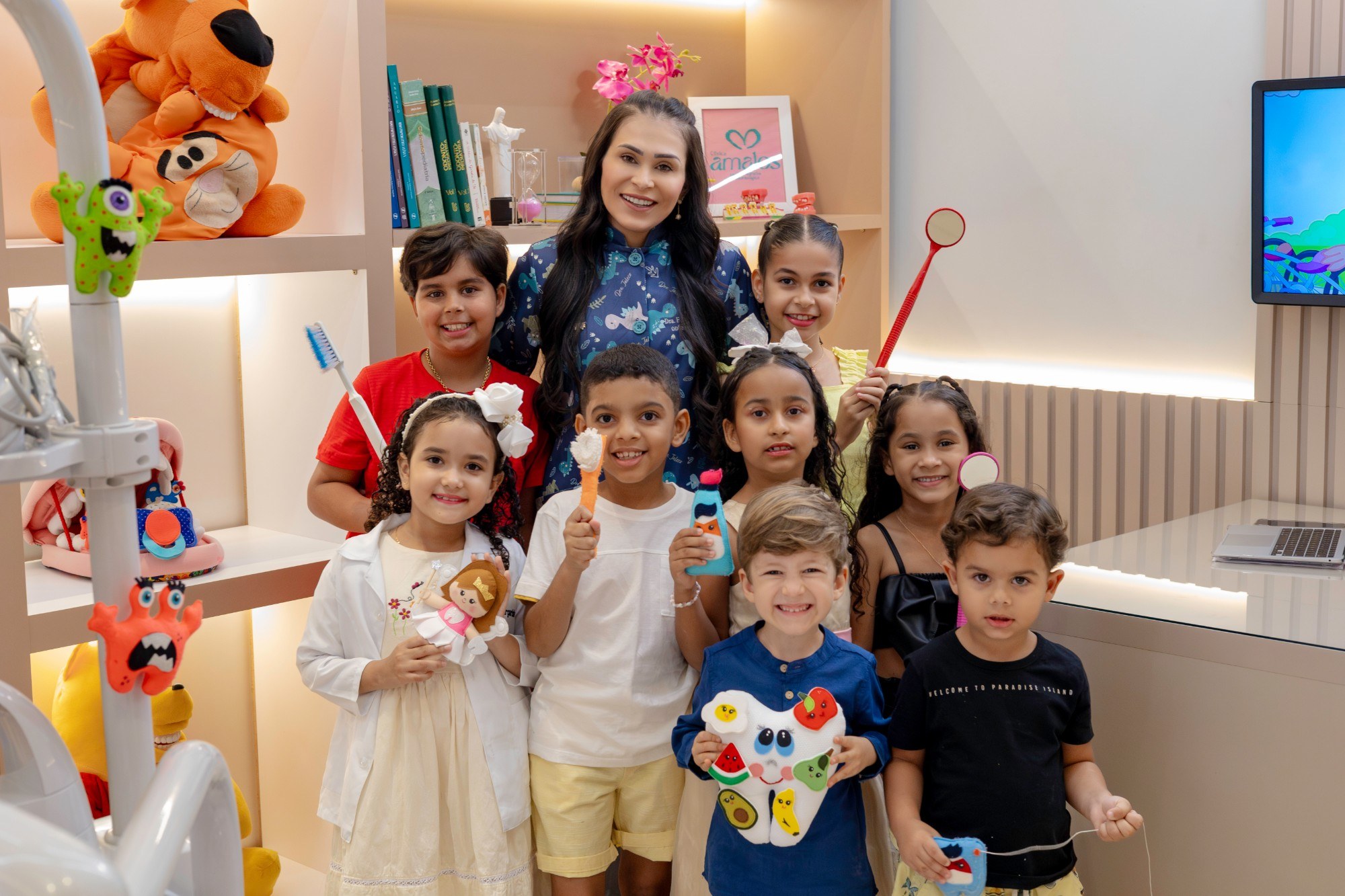 Dra. Edivânia Barboza com crianças no consultório da Clínica Amalos